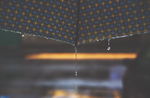 Kuvassa vesi tippuu sateenvarjon reunasta.